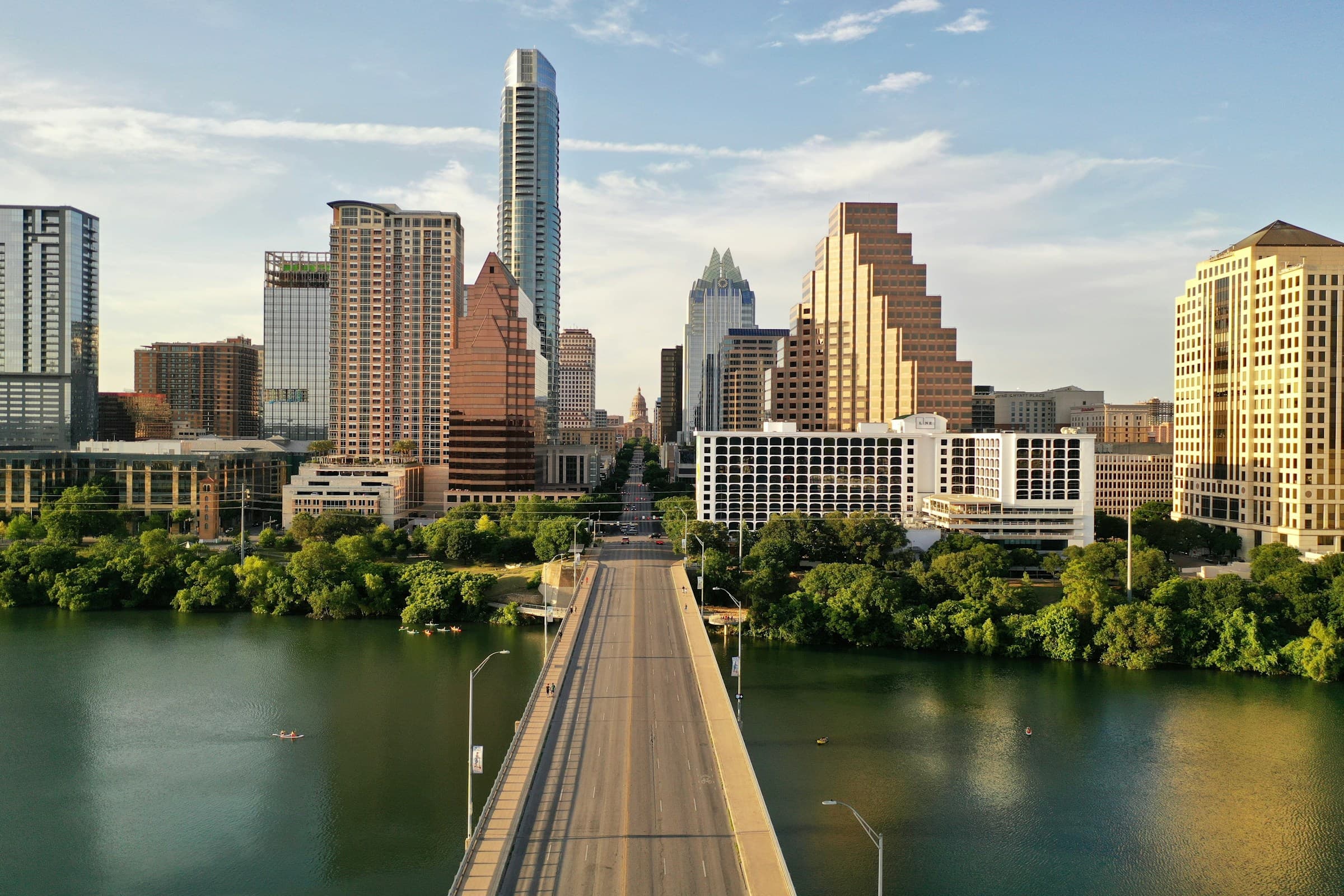 The Austin skyline at dusk, seen across a bridge over the river